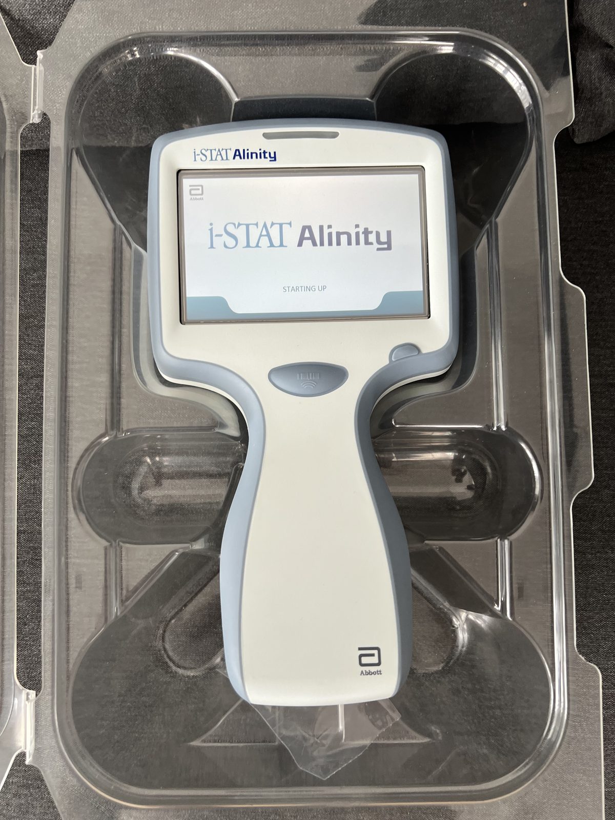 Abbott i-STAT Alinity analyser powered on and starting up, in the fitted tray of its carrying bag