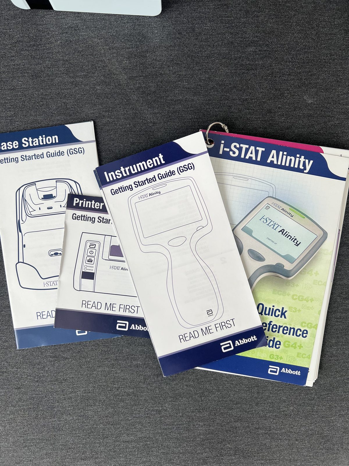 Printed Abbott documentation set: quick reference guide plus getting started guides for the instrument, printer and base station